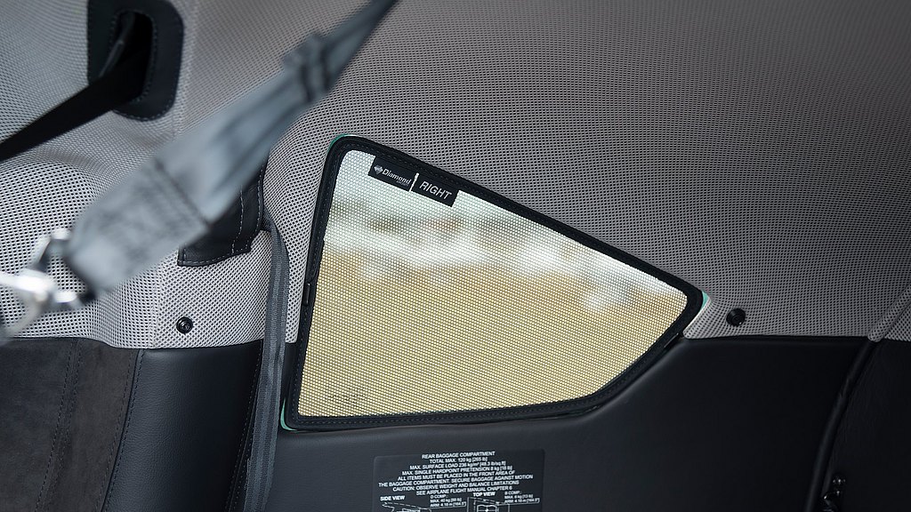 An interior shot highlighting a sunshade with a mesh texture, labeled 'RIGHT,' against a backdrop of the aircraft's cabin.