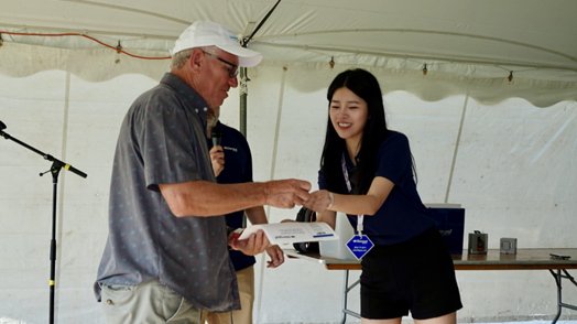 Woman handing over a present to a man.