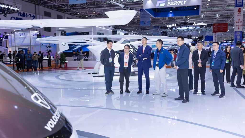 Attendees at an aviation expo gather around Volocopter eVTOL designs, highlighting advancements in urban air mobility.