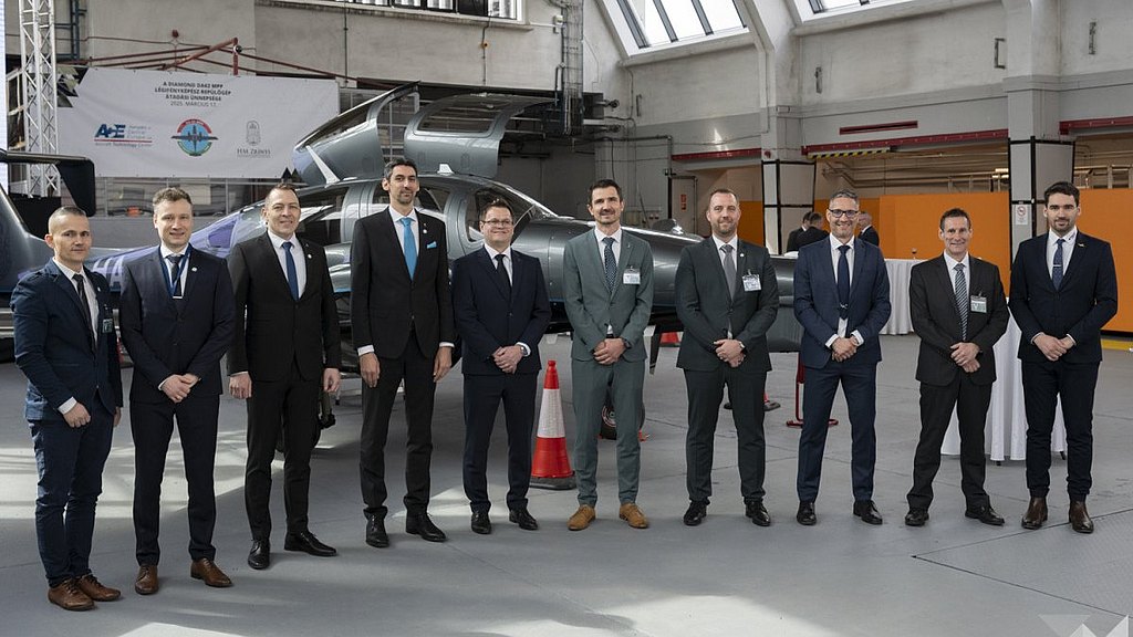 Group of men standing in front of a DA62 MPP in a hangar
