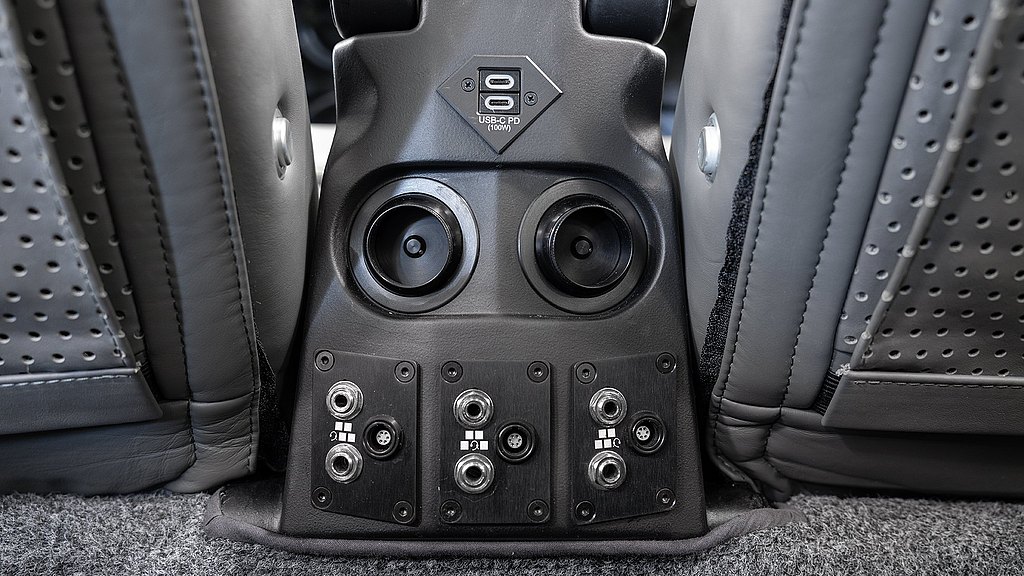 Detailed image of a modern audio connection panel with USB-C and various audio jacks, integrated into a stylish seating area.