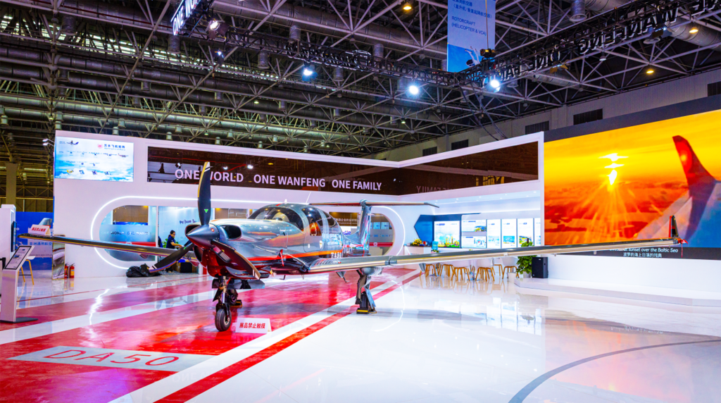 A DA50 RG stands prominently in a modern exhibition space, surrounded by displays and a vibrant atmosphere.