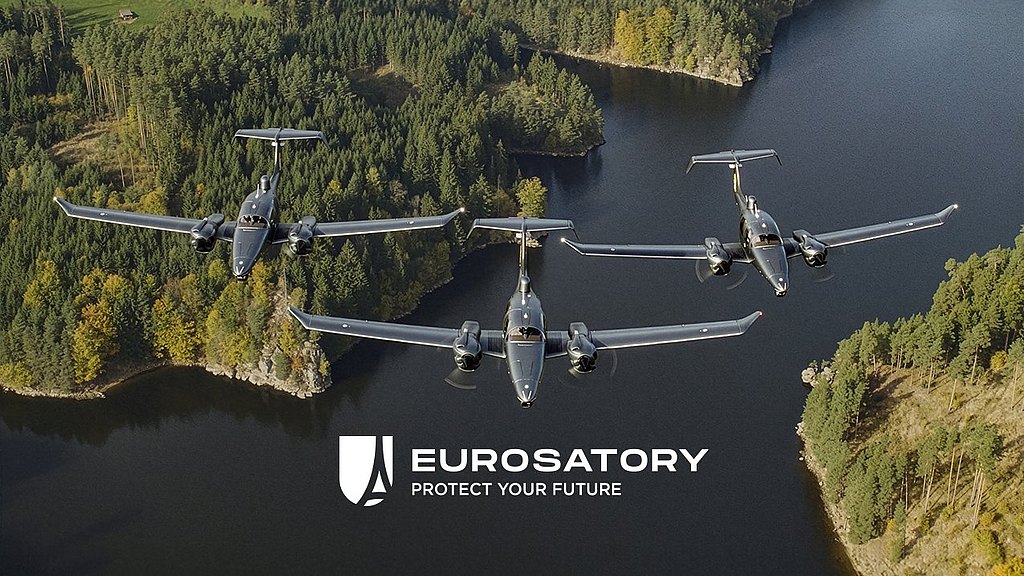 Three DA62 MPP aircraft fly in formation over a lush green forest and a serene lake, showcasing advanced aerial capabilities.
