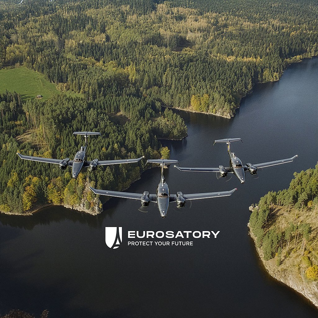 Three DA62 MPP aircraft fly in formation over a lush green forest and a serene lake, showcasing advanced aerial capabilities.