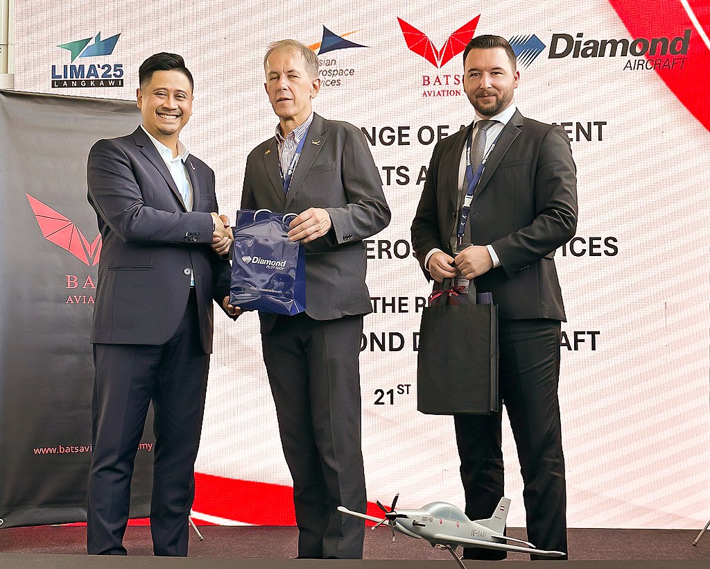 Three men in suits standing at a stage shaking hands. 