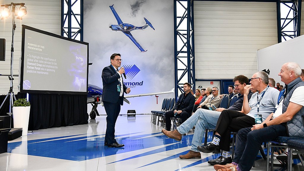 A man with a microphone speaking to the audience during the event. 