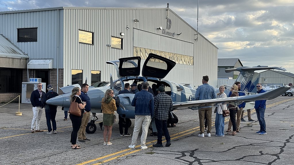 Group of people standing around a DA62.