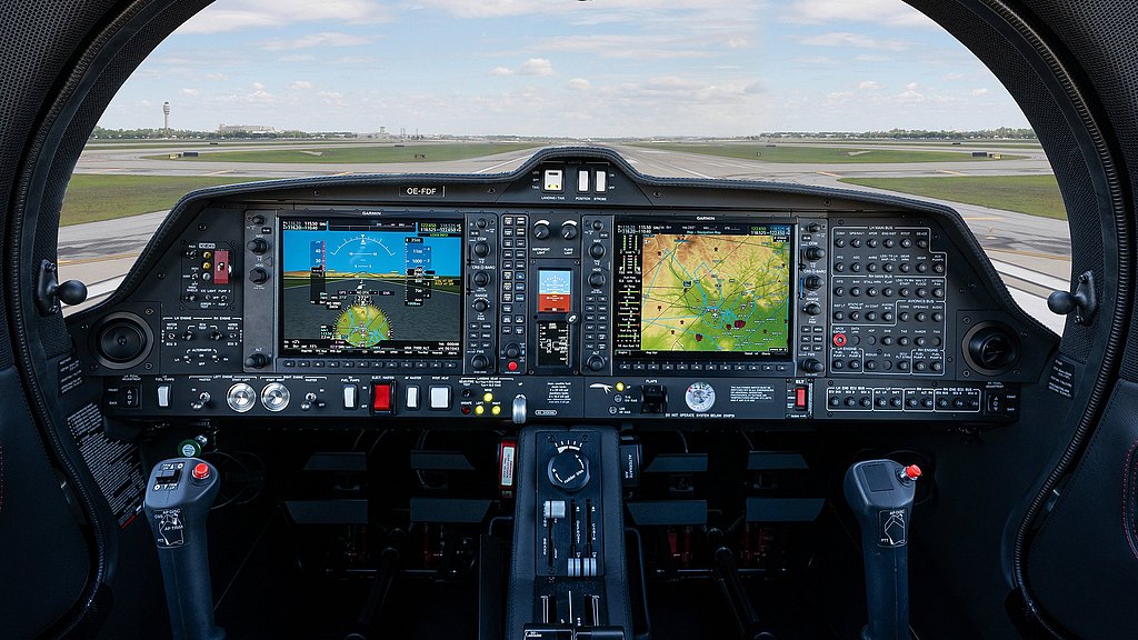 The cockpit features advanced avionics with multiple screens displaying flight data and navigation maps, set against a runway view.