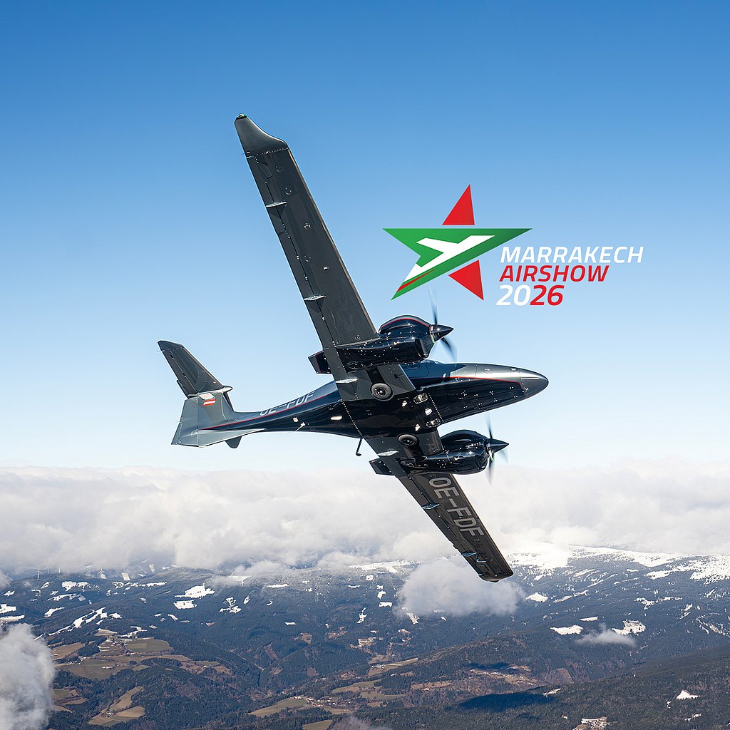 A DA62 aircraft soars through a clear blue sky, showcasing its impressive design against a backdrop of fluffy clouds.