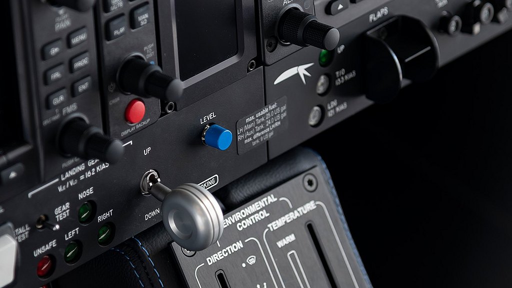 A close-up view of an aircraft control panel featuring various buttons, knobs, and screens, highlighting the retunr-to-level blue button.