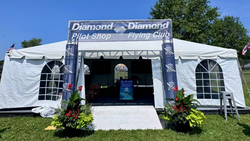 Large white Pilot Shop tent at the booth.