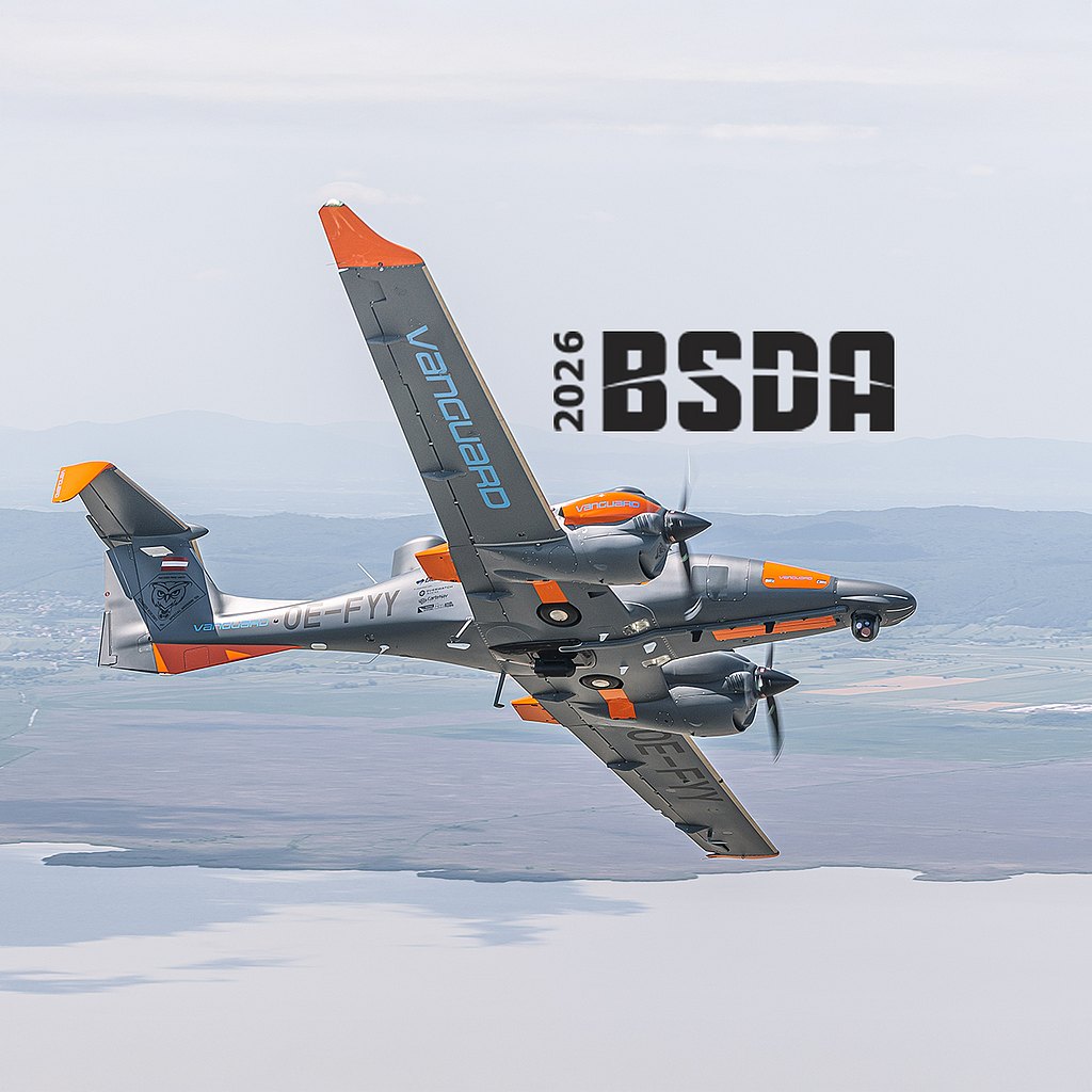 A DA62 MPP aircraft with orange accents soars through a clear sky, showcasing its impressive design and agility in flight.