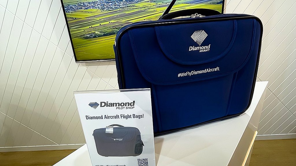 In a modern setting, a stylish blue bag branded with Diamond Aircraft is prominently featured alongside a promotional sign.