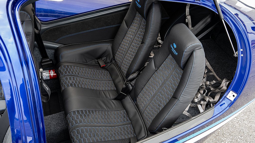 The interior features two modern passenger row seats, designed for comfort and safety.