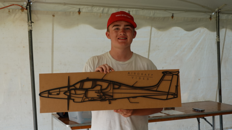 Young Man holding a DA62 artwork present. 