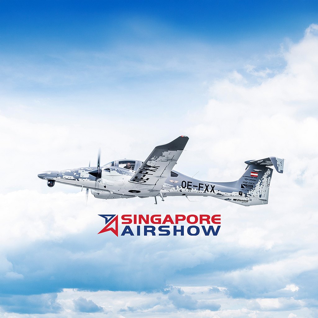 A sleek aircraft with a distinctive owl logo soars through a cloudy sky, showcasing its elegant design and capabilities.